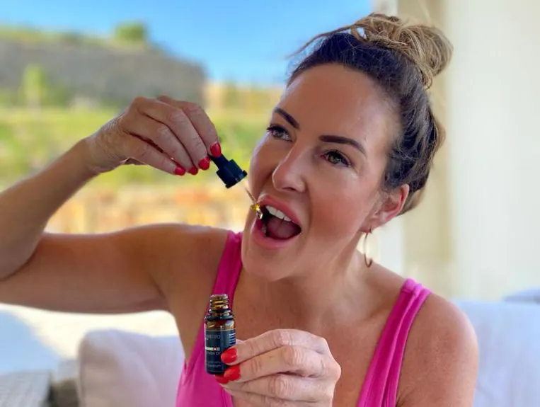 a woman taking a dose of 2000mg full spectrum cbd oil.