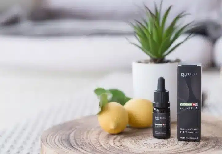 une bouteille de cbd assis à côté d'un citron