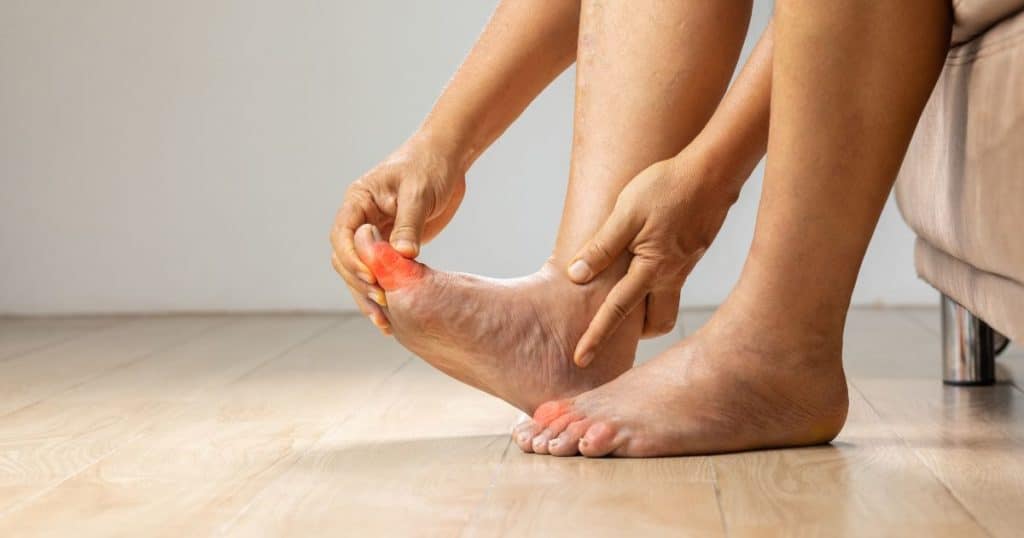a person holding their foot in pain caused by gout.