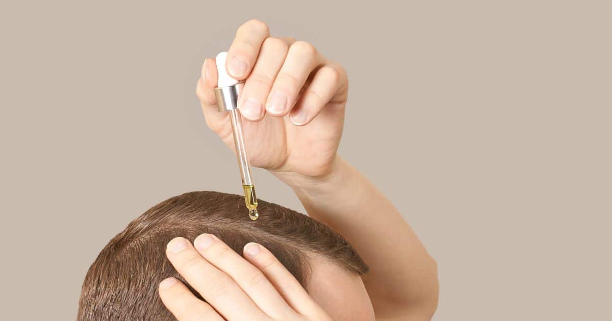 A person adding CBD oil to their hair.