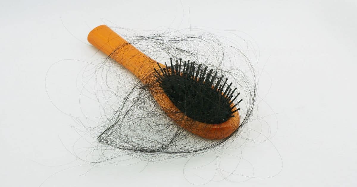 eine Haarbürste voller Haare, um dünner werdendes Haar darzustellen.