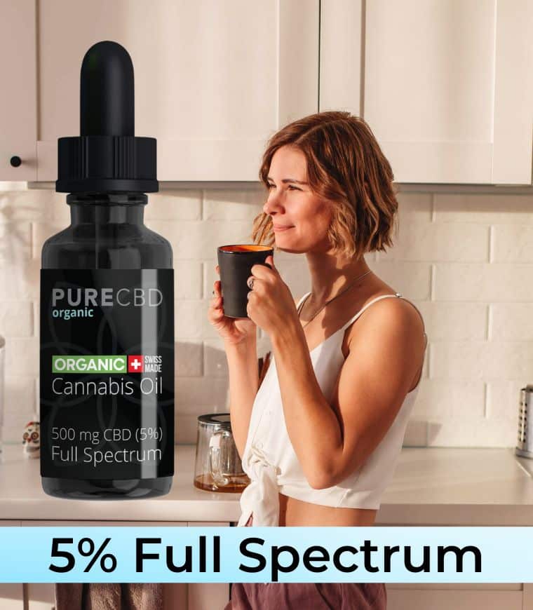 Una mujer tomando café con una sonrisa en su rostro. Hay una botella de 5% Full Spectrum CBD aceite en primer plano, que es nuestro mejor vendedor para el control del estrés.